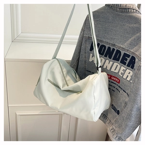 Detailed shot of white large capacity nylon shoulder bag with zipper and wide strap