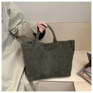 Détail du sac cabas en velours côtelé vert olive avec broderie noire et poignée solide