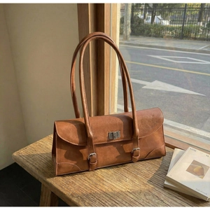Detail of vintage brown baguette bag with silver twist lock and distressed leather finish