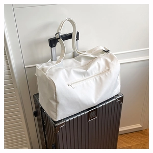 Detail of white nylon travel bag with zipper pocket on a metallic suitcase