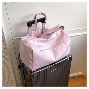 Detail view of pink travel bag sleeve fixed on a silver suitcase handle for convenience