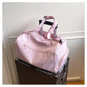 Pink large travel duffel bag with back sleeve attached to a silver suitcase handle