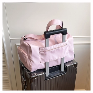 Pink fitness travel bag with luggage sleeve attached to a silver suitcase handle