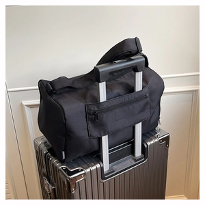 Detail view of black travel bag with trolley sleeve secured to luggage handle
