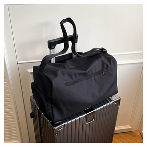 Macro shot of a black travel bag with a trolley sleeve attached to a silver suitcase