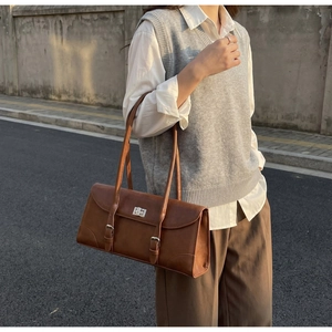Detailed macro view of the vintage brown underarm bag with silver twist lock and straps
