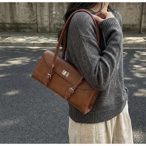 Retro brown baguette shoulder bag with metal turn-lock and vintage strap buckles detail