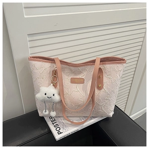 Detail of pink quilted tote bag with star pattern, leather logo and plush cloud charm