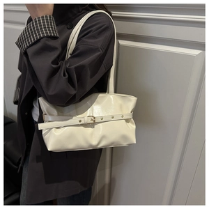Detail of a creamy white waxed leather shoulder bag with buckle and metal eyelets