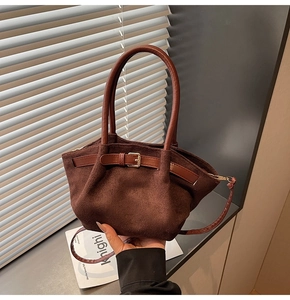 Close-up of a vintage brown crossbody bag featuring golden hardware and matte texture details