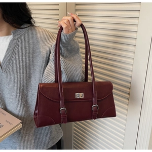 Detail of burgundy PU leather underarm bag with vintage metal twist lock and dual straps