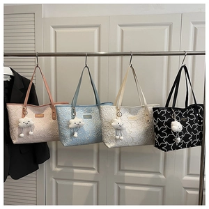 Detail of four colorful quilted tote bags with cute plush cloud charms and star patterns