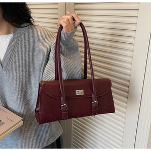 Detail of vintage burgundy underarm bag with silver twist lock and matte leather finish