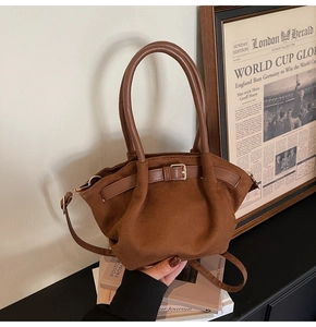 Detailed macro view of dark brown frosted leather texture and vintage handle buckle on crossbody bag