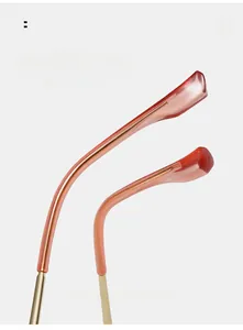 Detail view of red amber curved mirror legs with gold metal inlay for glasses