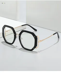 Detail der polygonalen schwarzen Brille mit hohlen Seiten und goldenen Metallbügeln
