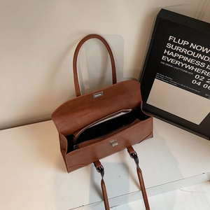 Brown rectangular underarm bag with matte finish and silver metal twist lock closure