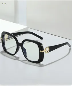 Detailed close-up of glossy black square frames with decorative gold metal hinge accents