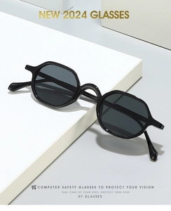 Detail of modern hexagonal black frame safety glasses with dark grey protective lenses