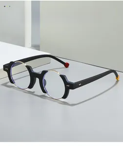 Detail of irregular black and gold glasses frame with red and yellow spherical temple tips