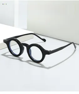Side view of retro round eyewear frame with thick polished black rims on white platform