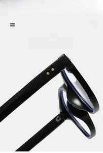 Detail view of black acetate eyeglass frames showing gold hinge rivets and flexible temple