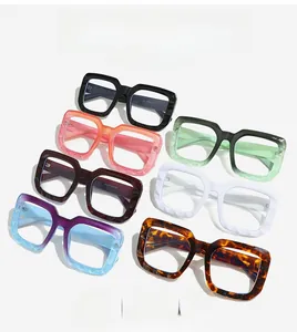 Seven pairs of chunky square oversized eyeglasses in diverse colors on light grey background