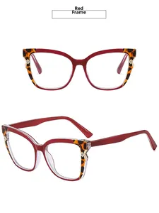 Detail view of red cat-eye glasses with leopard pattern tips and gold metal rivets