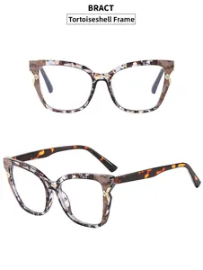 Close-up of cat-eye frames with tortoiseshell pattern and gold X-shape rhinestone hinge detail