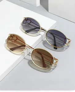 Détail de lunettes Y2K ovales en métal avec branches en cœur et verres à dégradé de couleurs