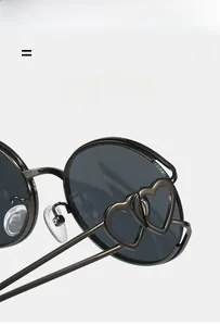 Détail des lunettes Y2K montrant les charnières en cœur et la monture noire légère