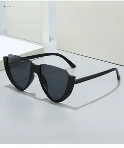 Detail view of stylish black cat-eye sunglasses with V-shape rimless cut and dark lenses