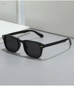 Details von eckigen schwarzen Sonnenbrillen mit dunkelgrauen Gläsern und Goldakzenten