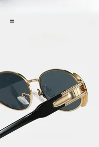 Close-up of golden metal hinges and black temples on vintage oval hip-hop sunglasses