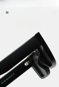 Macro shot of glossy black sunglasses frames showing precise metal hinge and arm details