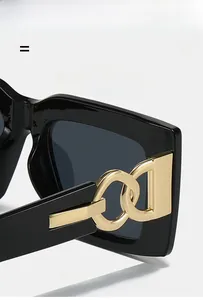 Macro shot of gold link metal hinges on vintage black square frame sunglasses