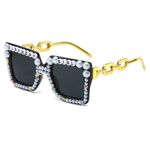 Lunettes Birthday Girl avec perles bleues et branches en chaîne dorée sur fond blanc