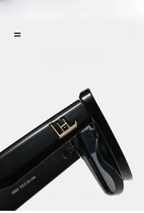 Gros plan de lunettes de soleil noires oversize avec logo doré et détails de taille