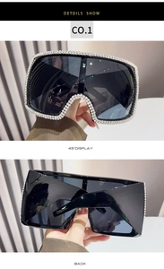 Detail showing oversized square sunglasses with dense rhinestone inlay and deep black lens