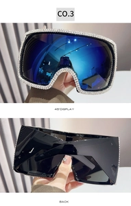 Detail of oversized square sunglasses with hand-set rhinestones and blue mirrored lenses
