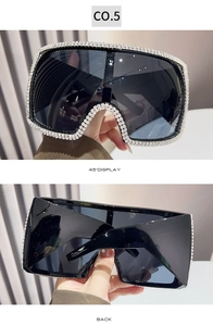 Macro detail of oversized square sunglasses featuring hand-set white rhinestones and dark lenses
