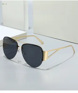 Detail of semi-rimless aviator sunglasses with gold metal frame and triangle temple cutout