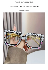 Detail of square glasses with Birthday Girl beads and pearl embellishments on gold chain legs