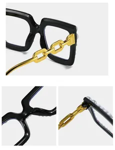 Detail of square glasses with gold chain temples and pearl embellishments on black frames
