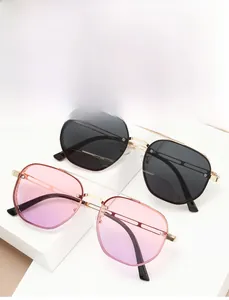 Close-up of steampunk sunglasses with gold metal frames and pink gradient lenses