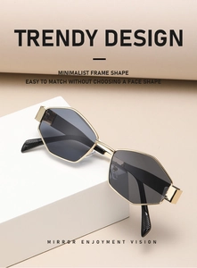 Detail der goldenen Metall-Sonnenbrille mit dunklen Gläsern auf weißem Podest
