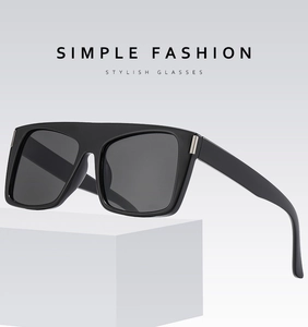 Detail shot of black square frame sunglasses with silver temple accents on a white stand
