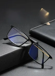 Detail of square black frame glasses with blue light lenses and gold metal hinges