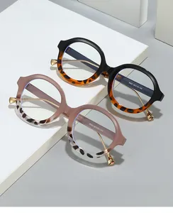 Detail of round frame blue light glasses with golden temples on white platforms