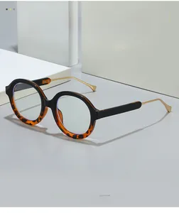 Detail of round frame blue light glasses with black tortoiseshell and gold temples